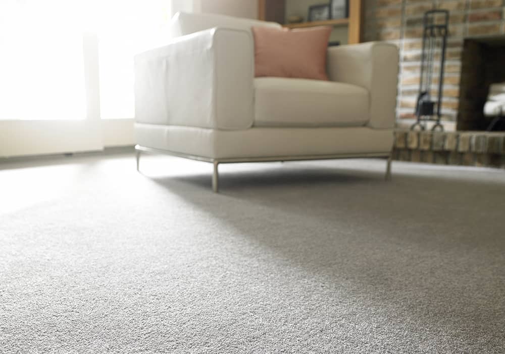 Grey carpet laid in living room with armchair