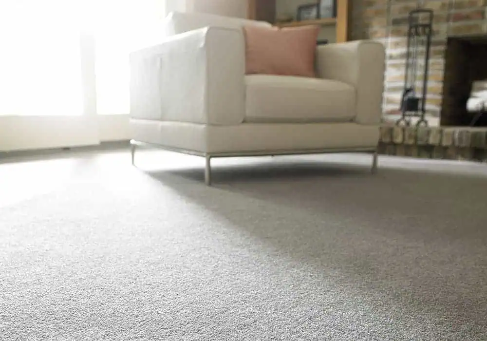 Grey carpet laid in living room with armchair