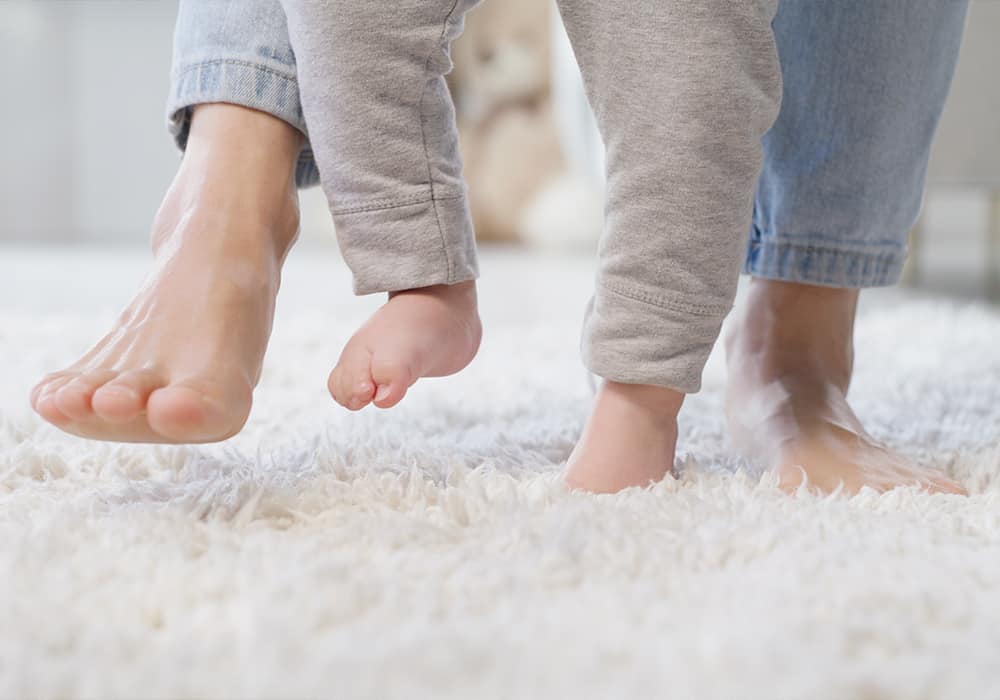 Woman and baby walking on a comfortable carpet with underlay underneath