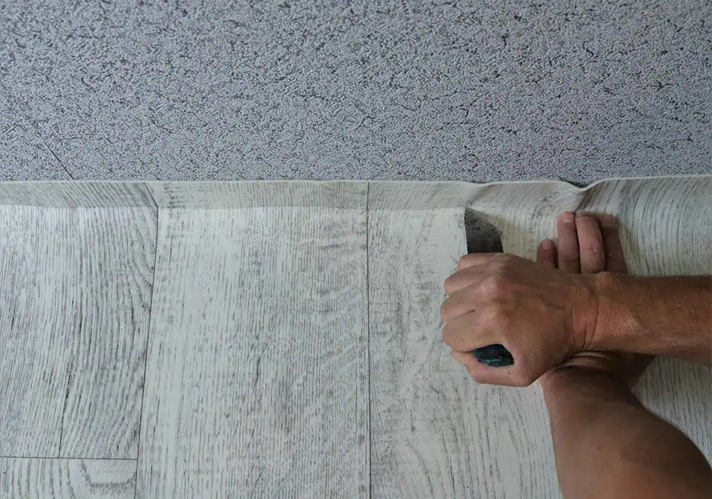 Man installing modern vinyl/lino sheet flooring