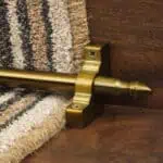 Homepride Stair Carpet Runner Rod in Bronze with a striped carpet on wooden stairs