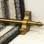 Homepride Stair Carpet Runner Rod in Bronze with a striped carpet on light white washed wooden stairs