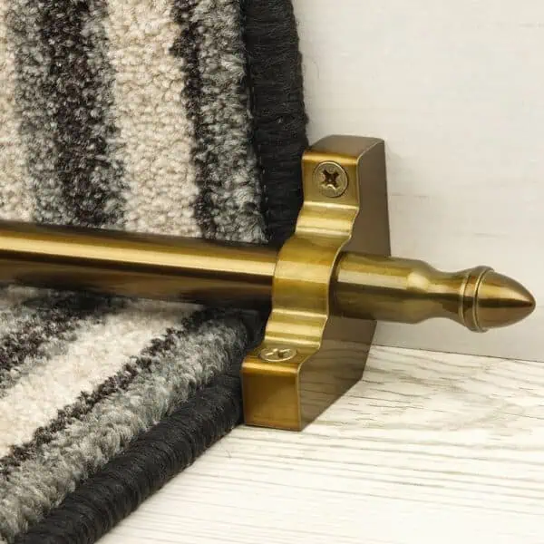 Homepride Stair Carpet Runner Rod in Bronze with a striped carpet on light white washed wooden stairs
